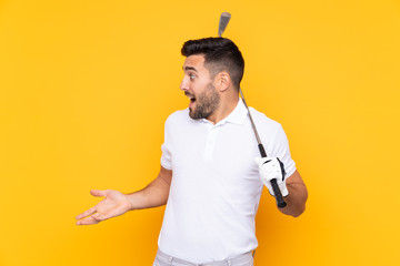 Golfer player man over isolated yellow background with surprise facial expression