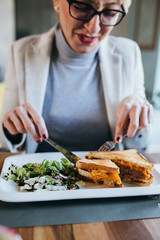 close up woman eating breakfast or lunch in restaurant
