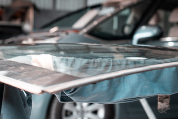 Car repair service, man working on glass replacement. Windshield insurance, safety and driving concept. Automotive industry.