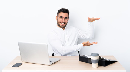 Young businessman in a workplace holding copyspace to insert an ad