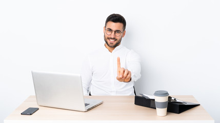 Young businessman in a workplace showing and lifting a finger