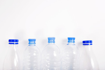 Empty plastic bottle with a blue cap on a white background