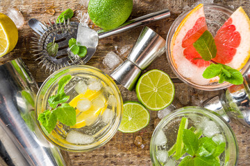Summer detox beverage  concept. Citrus fruit drinks with ice. Healthy diet cocktail with making bar tools.  Vitamin fortified water