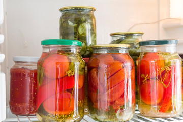 Canned vegetables in glass jars in the refrigerator. Home cooking and preservation