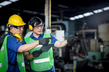 Two asian maintenance engineers discuss inspect relay checking information and protection system on...