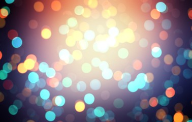 Colorful shiny bokeh on dark background. New year disco party glitter decoration. Yellow orange turquoise lights pattern.