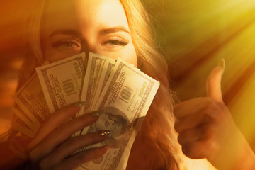Portrait of young beautiful woman with US Dollar bills making Ok gesture as if she want to say: Money really can buy You happiness.