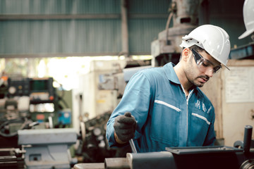 Professional engineer maintenance industrial in factory. Engineer looking of working at industrial machinery setup in factory. The engineering looks stern about the machine settings in the factory.
