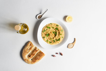 Hummus plate, its ingredients, bread  on white  background with copy space