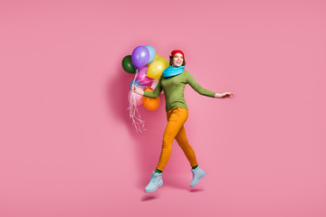 Full length photo of cheerful dreamy girl jump hold many air balls balloons look copyspace go walk enjoy spring occasion wear red sweater shoes isolated over pink color background