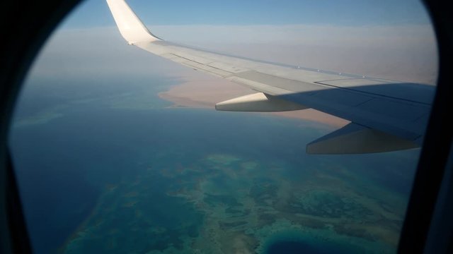 Plane airplane airliner aircraft flies over coral reefs in azure Red sea. Aviation tourist flights by air 