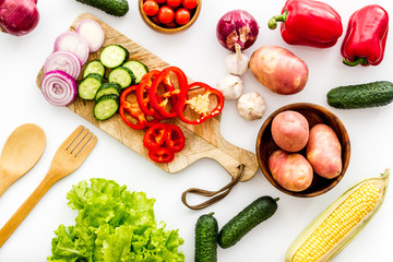 Fresh vegetables still life. Potato, cucumber, beet carrot, greenery on white background top-down