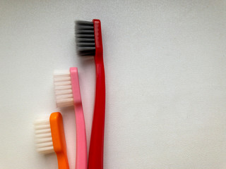 three multi-colored toothbrushes on a white background