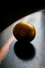 Easter golden egg on a wooden table. Painted egg silhouette , selective focus