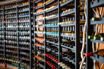 Resting wine bottles stacked on wooden racks in cellar
