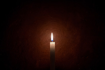 A candle burning, grungy wall background and vignette