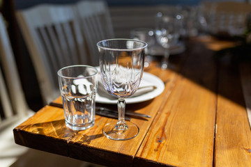 Glasses, forks, knives, plates on a table in restaurant served for dinner. Set dining table in loft style