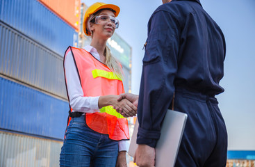 Engineer and worker handshake with blurred containers cargo background, Success and Teamwork concept