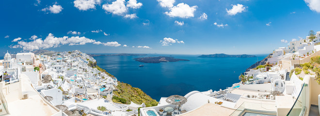 Naklejka premium Oia town on Santorini island, Greece. Traditional and famous houses and churches with blue domes over the Caldera, Aegean sea, panorama