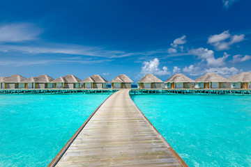 Fototapeta na wymiar Panoramic landscape of Maldives beach. Tropical panorama, luxury water villa resort with wooden pier or jetty. Luxury travel destination background for summer holiday and vacation concept.
