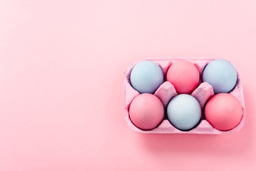 High angle view of painted easter eggs in egg tray on pink