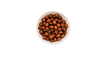 Round white bowl with hazelnuts isolated on a white background. Brown walnut kernels in a plate. Top view, flat lay.