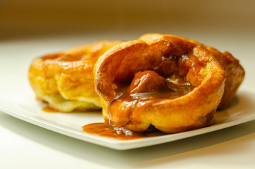 Traditional English Yorkshire pudding with meatballs and thick gravy sauce