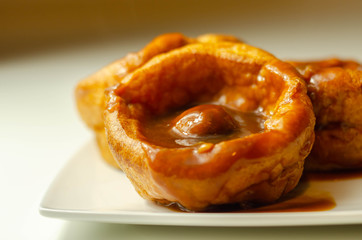 Traditional English Yorkshire pudding with meatballs and thick gravy sauce