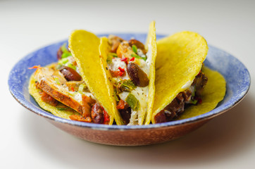 Mexican tacos shells with chicken and red kidney beans, onion,  red and green peppers, and salsa...