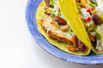 Mexican tacos shells with chicken and red kidney beans, onion,  red and green peppers, and salsa sauce