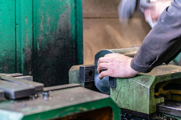 The worker sets the metal workpiece in a vice for processing on a CNC milling machine.