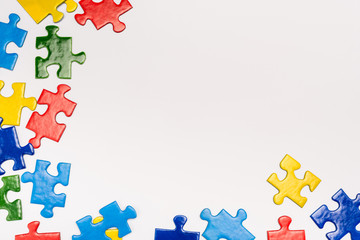 Top view of colorful pieces of puzzle on white background, autism concept