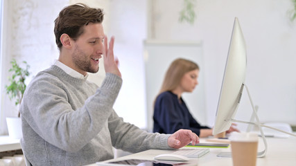 Obraz premium Cheerful Man doing Video Chat on Desktop