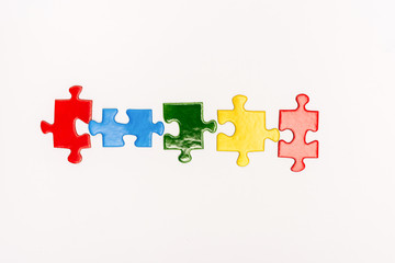 Fototapeta premium Top view of bright pieces of puzzle isolated on white, autism concept