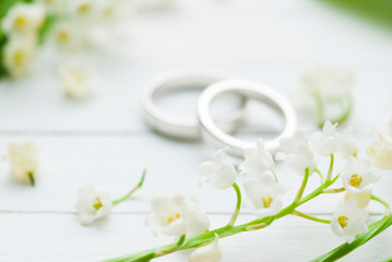 Plakat Lily of the valley with wedding rings on white wooden