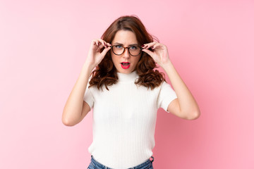 Young Russian woman over isolated pink background with glasses