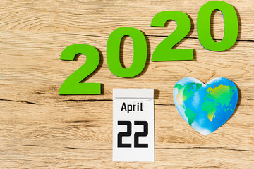 Top view of date 22 april 2020 and globe on wooden background, earth day concept
