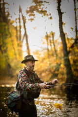 Handsome fisherman holding a lovely trout while  fly fishing on a splendid mountain river