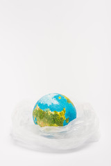 Globe inside plastic bag on white background, global warming concept