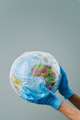 doctor with a world globe wrapped in plastic.