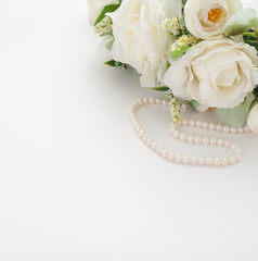 White background with a wedding bouquet, pearl beads and a Cup of coffee with milk, with copy space. Concept backgrounds for wedding texts or romantic texts.