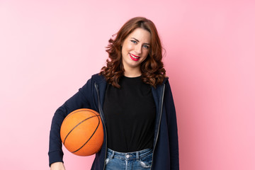 Young Russian woman over isolated pink background with ball of basketball