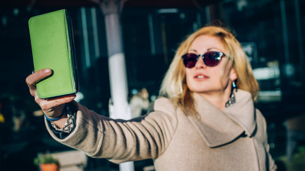 Woman taking selfie using her touch screen mobile cell phone