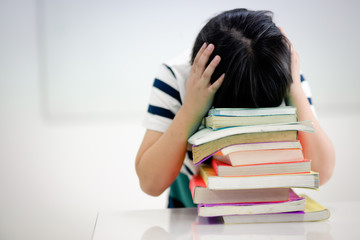 Boy student Sitting in a head in the library Headache with reading exam During the final exam of...