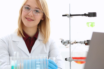 Smiling beautiful technician woman portrait and sample bottle with poison fluid. Medical worker in...