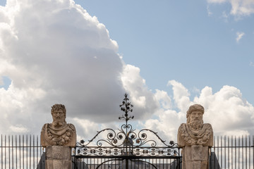 Fenced gate with two statues 
