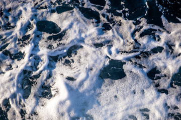 Top down aerial view of sea water surface. White foam waves texture as natural background.