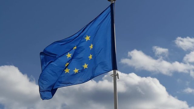 Waving flag of European Union on the blue sky
