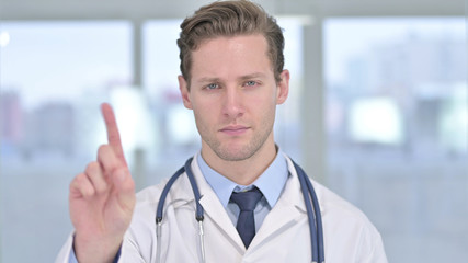 Portrait of Young Male Doctor saying No with Finger Sign