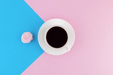 A cup of freshly brewed coffee on beautiful pink and bright blue pastel background.